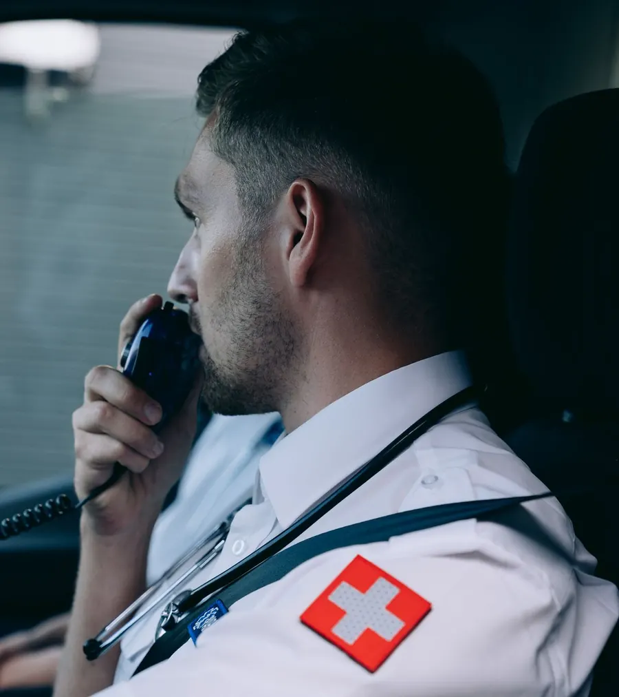 A paramedic using a radio inside an ambulance